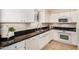Bright kitchen featuring white cabinets, black countertops, and modern appliances at 7800 E Lincoln Dr # 1035, Scottsdale, AZ 85250
