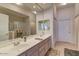 Bathroom featuring double sinks, a large mirror, a separate shower and tub, and ample counter space at 8245 E Bell Rd # 128, Scottsdale, AZ 85260