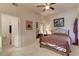 Cozy bedroom featuring a ceiling fan, carpeted floors, and a comfortable bed with ornate metal frame at 8245 E Bell Rd # 128, Scottsdale, AZ 85260