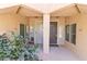 Condo entrance with brown front door flanked by windows and desert landscaping at 8245 E Bell Rd # 128, Scottsdale, AZ 85260