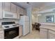 Kitchen showcasing matching white appliances, light countertops, and a dining area in the background at 8245 E Bell Rd # 128, Scottsdale, AZ 85260