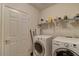 Laundry room with a white front-load washer and dryer and overhead shelving at 8245 E Bell Rd # 128, Scottsdale, AZ 85260