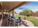 Relaxing covered patio overlooks a spacious, low-maintenance backyard with lush artificial turf at 8307 S Desert Preserve Ct, Gold Canyon, AZ 85118