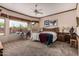 Spacious carpeted bedroom featuring a ceiling fan and large windows overlooking desert landscape at 8307 S Desert Preserve Ct, Gold Canyon, AZ 85118