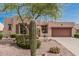 Charming desert landscaping complements this tan home with a two-car garage at 8307 S Desert Preserve Ct, Gold Canyon, AZ 85118