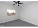 Cozy bedroom with neutral walls, a window overlooking palm trees, and a ceiling fan at 9035 E Lupine Ave, Scottsdale, AZ 85260