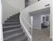 Elegant staircase with white railings and gray carpet runners leads to a light-filled landing at 9035 E Lupine Ave, Scottsdale, AZ 85260