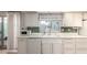 Bright kitchen featuring white appliances, cabinetry, green mosaic backsplash, and tile flooring at 10619 W Highwood Ln, Sun City, AZ 85373