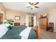 Spacious bedroom with ceiling fan, plush carpet, and entry to hallway at 1074 E Carla Vista Ct, Gilbert, AZ 85295