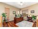 A well-lit home office with wood floors, large desk, plants, and a ceiling fan for a comfortable workspace at 1074 E Carla Vista Ct, Gilbert, AZ 85295