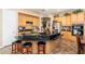 Kitchen island featuring black countertops, oak cabinets, and seating for three at the breakfast bar at 1074 E Carla Vista Ct, Gilbert, AZ 85295