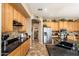 Bright kitchen with oak cabinets, black countertops, and stainless steel appliances at 1074 E Carla Vista Ct, Gilbert, AZ 85295