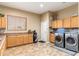 Laundry room with a washer and dryer, lots of cabinets, tile floor, and a window at 1074 E Carla Vista Ct, Gilbert, AZ 85295
