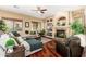 Inviting living room features hardwood floors, a stone fireplace, and built-in shelving at 1074 E Carla Vista Ct, Gilbert, AZ 85295