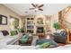 Inviting living room featuring a stone fireplace, hardwood floors, and abundant natural light at 1074 E Carla Vista Ct, Gilbert, AZ 85295