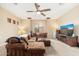 Cozy living room featuring a large sectional, ceiling fan, and comfortable carpeting at 1074 E Carla Vista Ct, Gilbert, AZ 85295