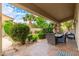 Covered patio with a dining table, chairs, desert landscaping and a blue sky overhead at 1074 E Carla Vista Ct, Gilbert, AZ 85295