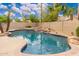 Sparkling pool with rock waterfall and lush landscaping, creating a private retreat at 1074 E Carla Vista Ct, Gilbert, AZ 85295