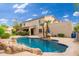 Spacious backyard with a gorgeous pool, lush landscaping, and a covered outdoor living area at 1074 E Carla Vista Ct, Gilbert, AZ 85295