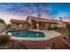 A backyard featuring a sparkling pool, patio space, and lush landscaping under a beautiful sunset at 10809 N 111Th Pl, Scottsdale, AZ 85259