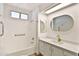Bright bathroom with a shower/tub combo, gold hardware, and an oval mirror over the vanity at 110 S 72Nd Way, Mesa, AZ 85208