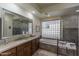 Bright bathroom featuring a glass block window, vanity, soaking tub, and separate shower at 11736 E Del Timbre Dr, Scottsdale, AZ 85259