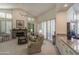 Relaxing living room featuring large windows, stone fireplace, neutral-toned furniture, and a ceiling fan at 11736 E Del Timbre Dr, Scottsdale, AZ 85259