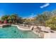 Gorgeous backyard pool with rock waterfall, mature landscaping, and pool cleaning system at 11736 E Del Timbre Dr, Scottsdale, AZ 85259
