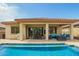 Covered patio with dining and lounge seating overlooks a sparkling pool on a sunny day at 12031 S 184Th Ave, Goodyear, AZ 85338