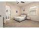 Bedroom with neutral walls, carpet flooring, ceiling fan and ensuite bathroom at 12031 S 184Th Ave, Goodyear, AZ 85338