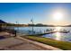 Scenic lake view with a wooden pier, benches, and gazebo under a clear blue sky at 12031 S 184Th Ave, Goodyear, AZ 85338