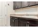 A functional laundry room with dark cabinets, a utility sink and ample counter space at 12031 S 184Th Ave, Goodyear, AZ 85338