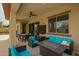 Covered outdoor patio featuring comfortable seating, a ceiling fan and a view of the pool at 12031 S 184Th Ave, Goodyear, AZ 85338