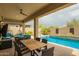 Relaxing outdoor patio with views of the pool, comfortable seating, and a ceiling fan at 12031 S 184Th Ave, Goodyear, AZ 85338