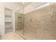 Tiled shower with glass door and built in niche located in primary bathroom at 12031 S 184Th Ave, Goodyear, AZ 85338