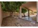 Lush backyard featuring a covered patio, mature trees, and low-maintenance gravel landscaping at 1211 W Hawken Way, Chandler, AZ 85286