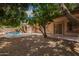 Backyard with a view of the pool and patio area, mature trees, and gravel landscaping at 1211 W Hawken Way, Chandler, AZ 85286