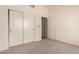 Bedroom with neutral carpet, bi-fold closet door, and a doorway to another room at 1211 W Hawken Way, Chandler, AZ 85286