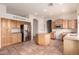 Kitchen with stainless appliances, wood cabinets, center island, and an arched entrance to living space at 1211 W Hawken Way, Chandler, AZ 85286