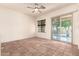 A spacious living room boasts tile flooring, a ceiling fan, and a glass slider to backyard at 1211 W Hawken Way, Chandler, AZ 85286