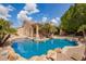 Beautiful backyard pool with rock features, landscaping, and access to covered patio at 1211 W Hawken Way, Chandler, AZ 85286