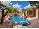 Backyard pool area surrounded by mature trees, rock features, and lush landscaping at 1211 W Hawken Way, Chandler, AZ 85286