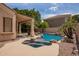 A pristine backyard pool and spa are surrounded by lush desert landscaping and a covered patio at 1211 W Hawken Way, Chandler, AZ 85286