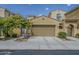 Beige two-car garage featuring desert landscaping and wrought iron pedestrian access at 1367 S Country Club Dr # 1189, Mesa, AZ 85210