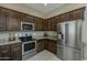 Well-equipped kitchen with stainless steel appliances and dark wood cabinetry and granite counters at 1367 S Country Club Dr # 1189, Mesa, AZ 85210