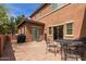Backyard patio with seating area and view of two-story home's stucco exterior at 14239 W Port Royale Ln, Surprise, AZ 85379