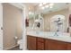 Well-lit bathroom featuring double sinks with dark wood cabinetry and a large mirror at 14239 W Port Royale Ln, Surprise, AZ 85379