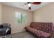 Bedroom features a ceiling fan, a window with blinds, and a futon at 14239 W Port Royale Ln, Surprise, AZ 85379