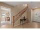 Inviting entryway with tile flooring, wood staircase, and views into the dining area at 14239 W Port Royale Ln, Surprise, AZ 85379