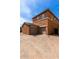 Exterior view of two-story home with a two-car garage, brick driveway and desert landscaping at 14239 W Port Royale Ln, Surprise, AZ 85379